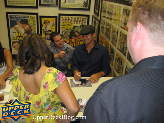 Tony chuckles while talking with reporter Jon Gold about the event while he signs photos for the members.