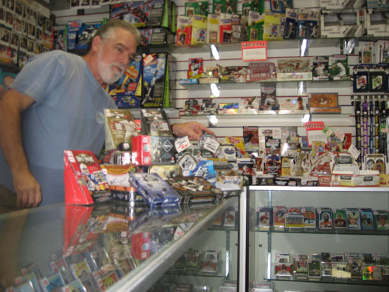 Ian behind the counter, helping a customer through their football offerings.